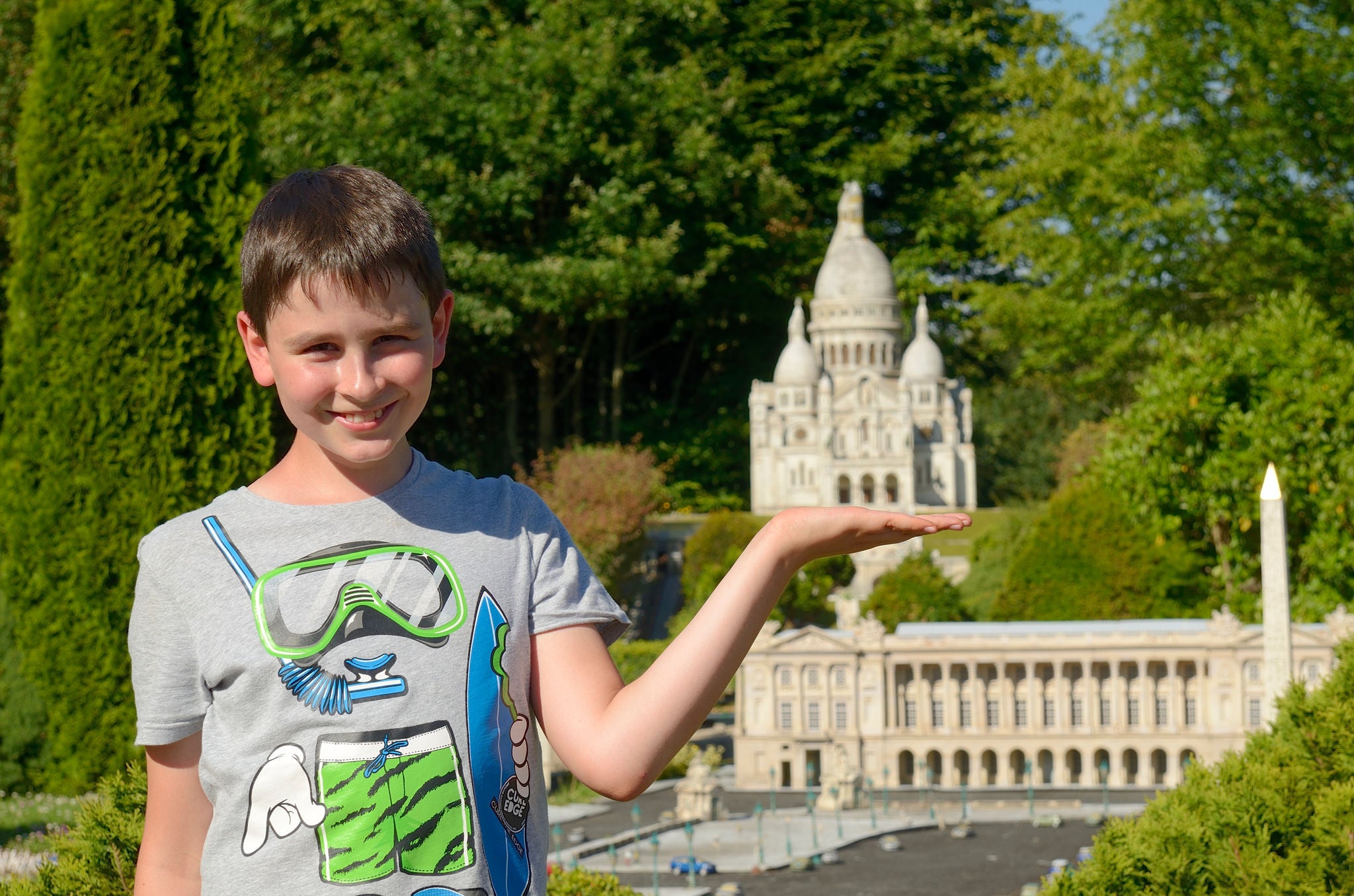 Boy posing in front of sacre coeur miniature at France Miniature