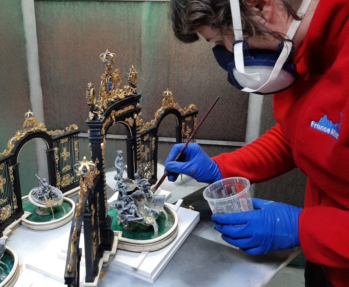 France Miniature employee working on the gates of place stanislas