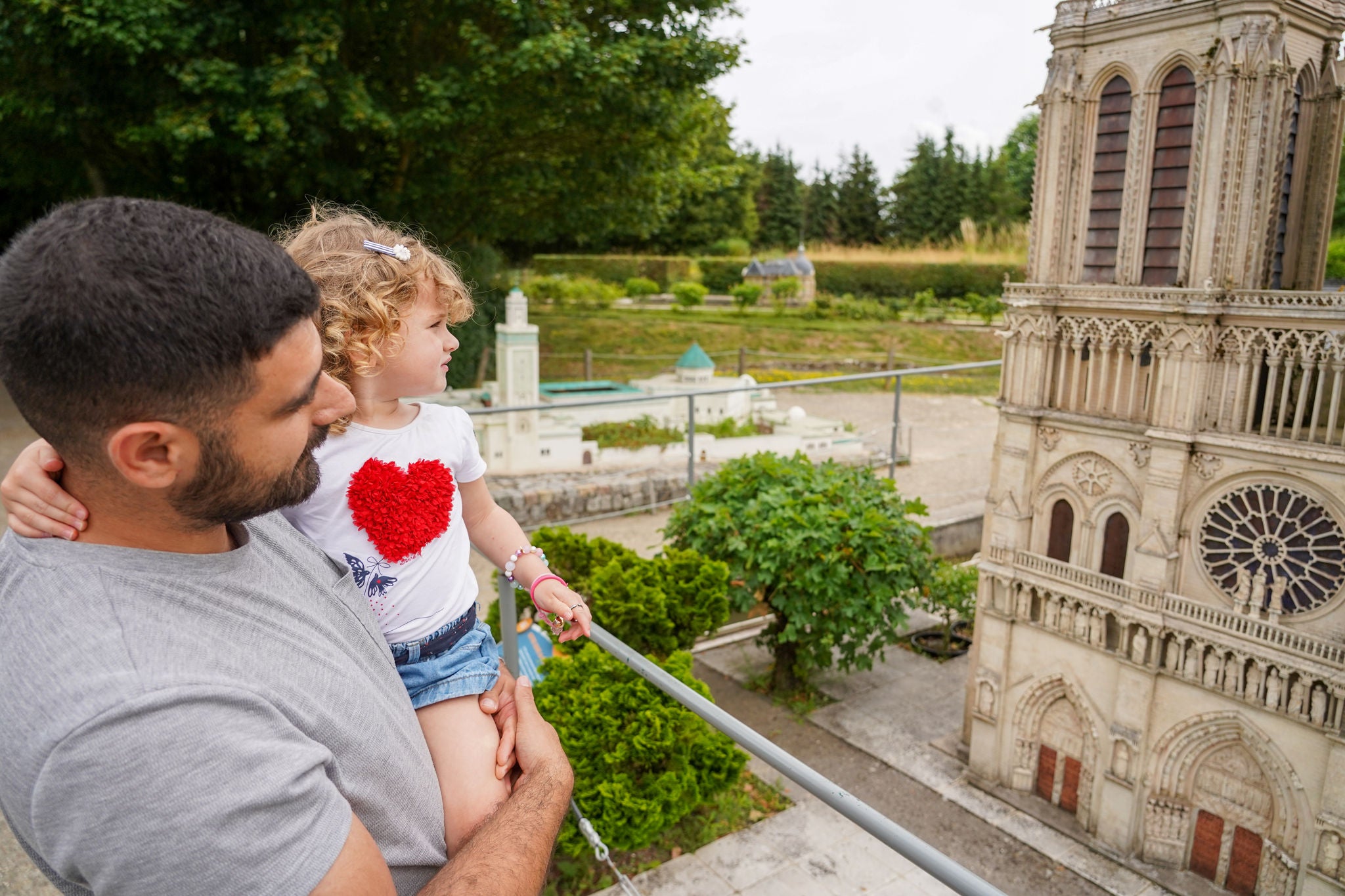 Father and child in front of Miniature Notre Dame at France Miniature